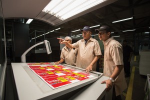 At the Printcare factory in Colombo, Ravindran inspects tea packaging destined for the United Kingdom. With him are his son, Krishna (right), and general manager Rohitha Grero.