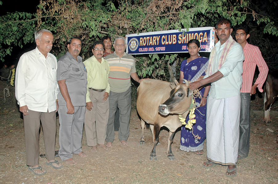 PDG Narayan Pandeshwar (left) along with Rotarians gifting a cow to a beneficiary.
