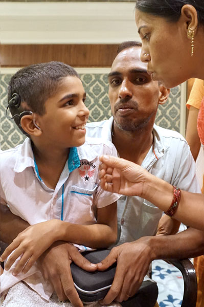 Young Nitin in conversation with his parents after his hearing has been restored, thanks to the cochlear implant.
