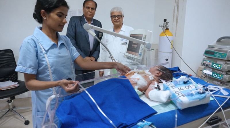Dr Suresh Rao, accompanied by D 3141 DG Gopal Mandhania examines an infant after surgery.