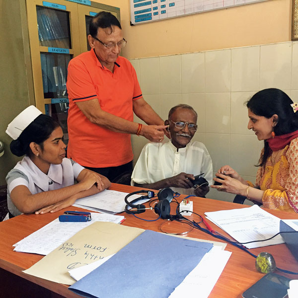 Team leader Gopal Sapra fixes hearing aid in a patient’s ear.