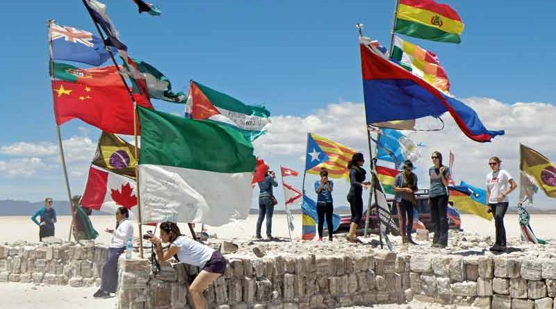 Flags from across the globe flutter on a platform of salt bricks.
