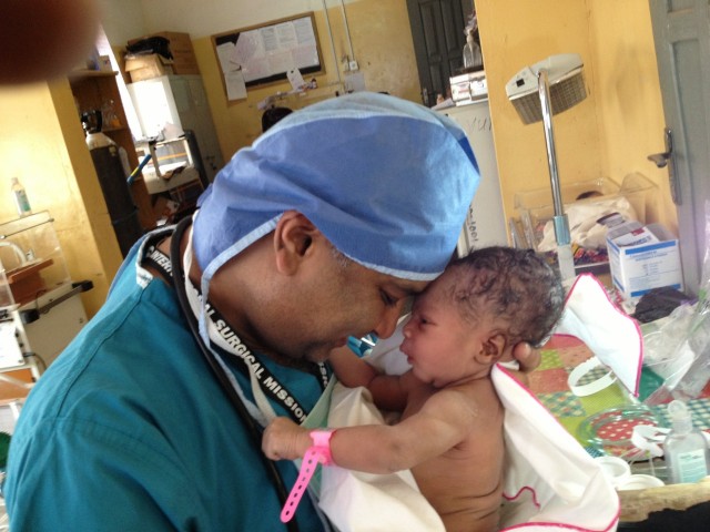 Riverhead surgeon Rajesh Patel, with a baby he helped deliver in Brazil. Courtesy photo: Rajesh Patel.