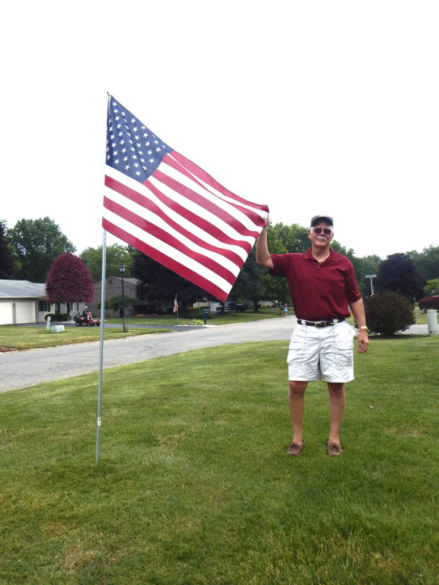 Ken Abell of Howland Rotary Club places an American flag in a yard in Howland as part of a new fundraiser by the Rotary. Photo: Tribune Chronicle / Bob Coupland