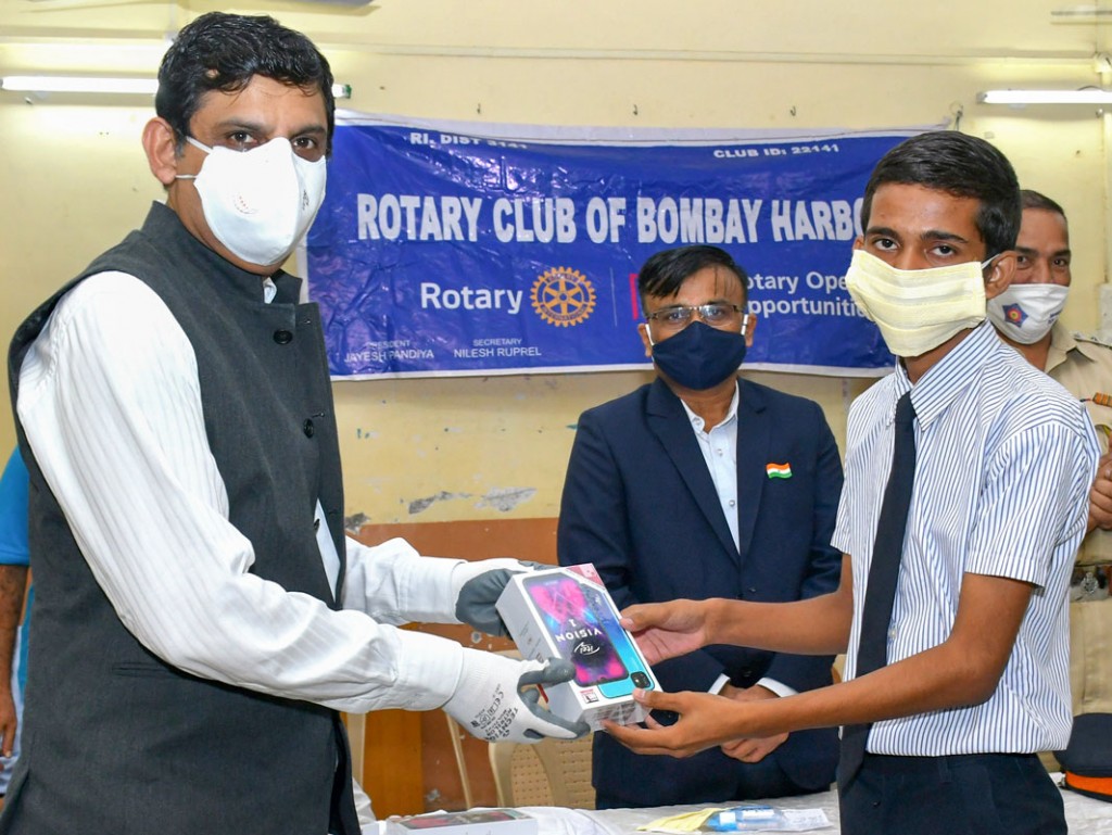 Club president Jayesh Pandya gifting a mobile phone to a student.