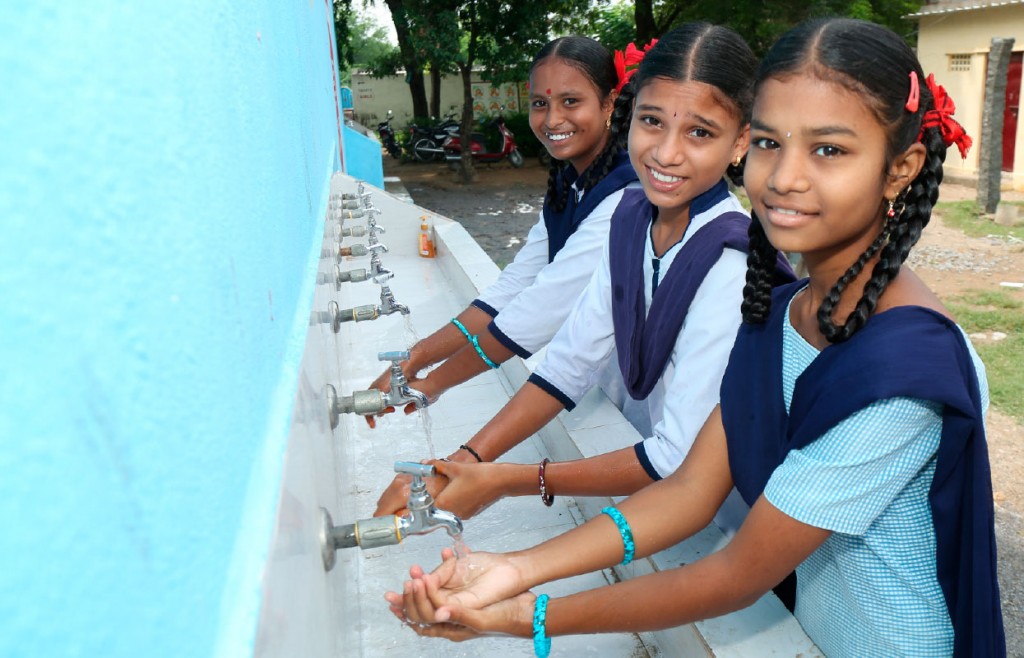 Students washing hands at a handwash station installed under WinS programme.