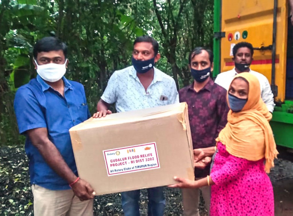 Tirupur Rotarians give relief material to a flood victim in Gudalur.