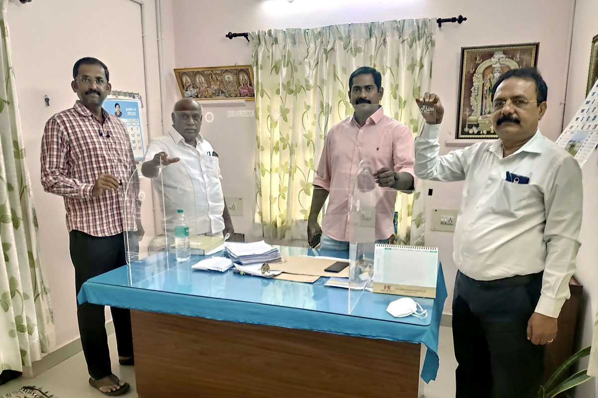 An acrylic Covid shield being installed at a police station by RC Coimbatore Vadavalli members.