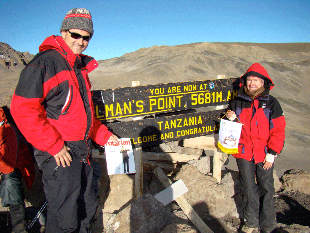 RIPN Jennifer Jones holding a Rotary banner and her husband Nick Krayacich holding a copy of The Rotarian at the Gillman’s Point before reaching the summit of Mount Kilimanjaro.