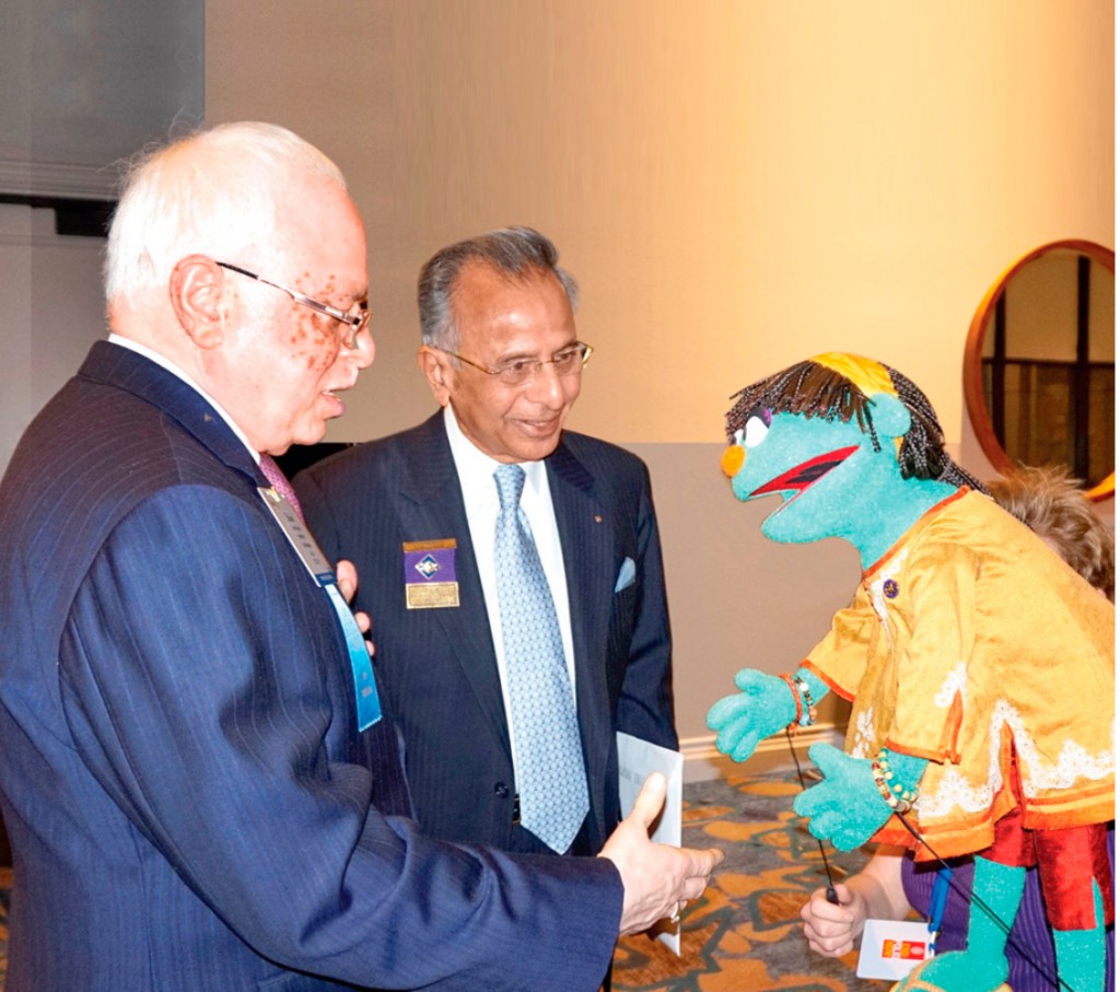 PRID Gupta and PRIP Rajendra Saboo greeting a muppet at the 2015 International Assembly.