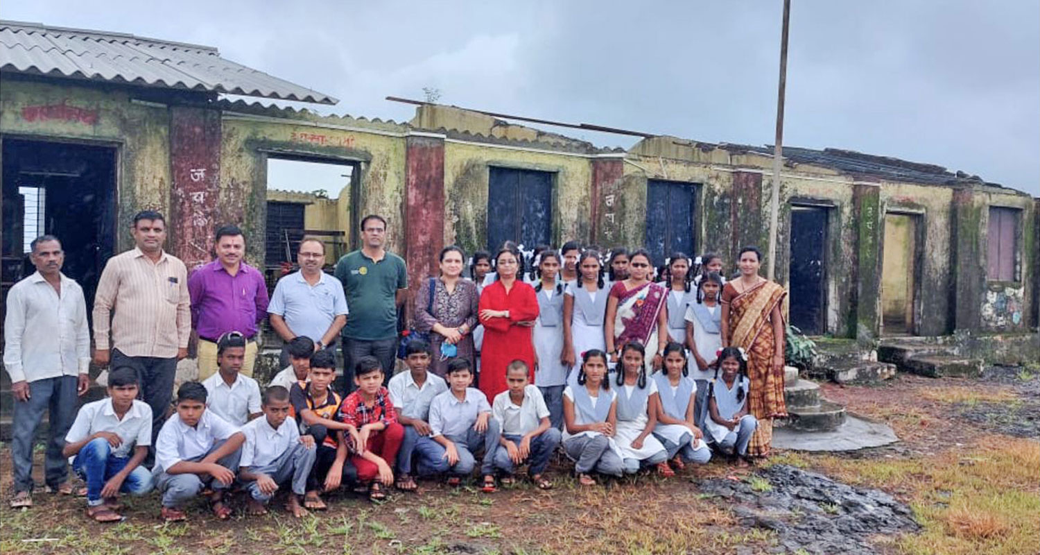 RC Thane North president Sunil Soman (fourth from L) along with Rotarians, teachers and students in front of the dilapidated school building. 