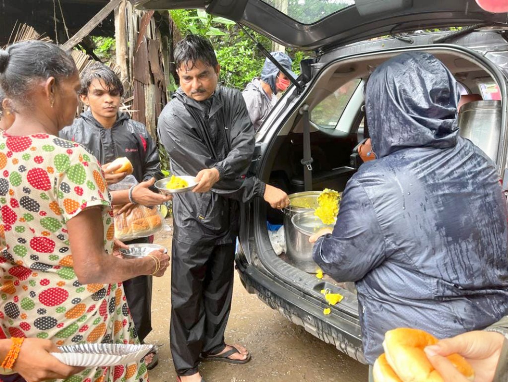 Club member Rajesh Patel and Rtr Raj Patel distributing food in a flood-hit area.