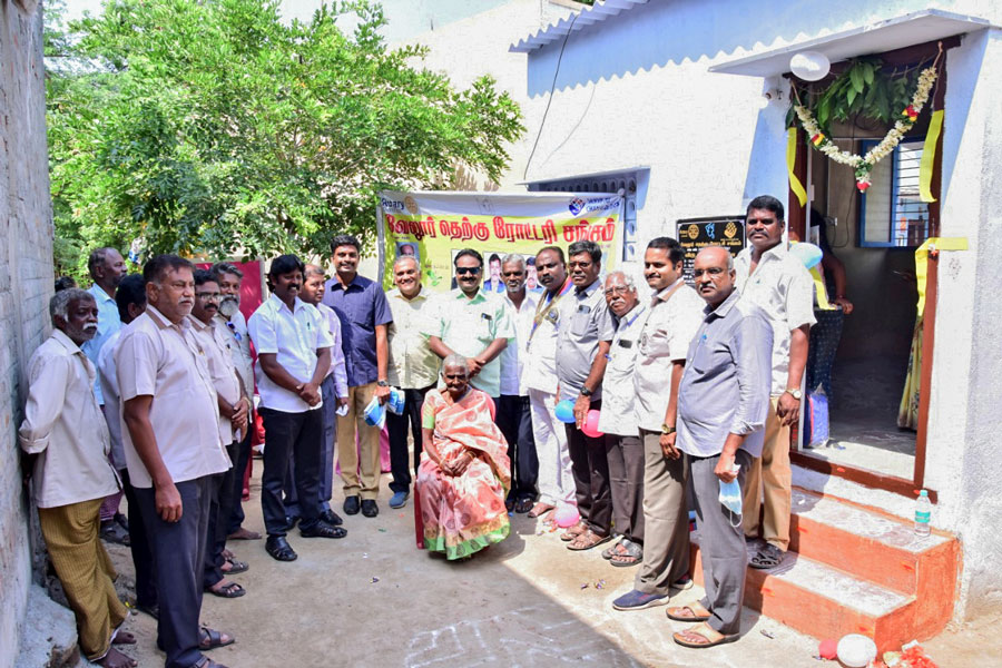 Members of RC Vellore South with a beneficiary in front of the newly constructed house.