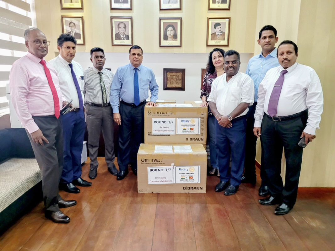RID 3220 DGE Jerome K Rajendram (L) handing over medicines given by RC Erode Central to Dr W K Wickramasinghe (fourth from L), Deputy Director General of Health Services at the Colombo National Hospital.