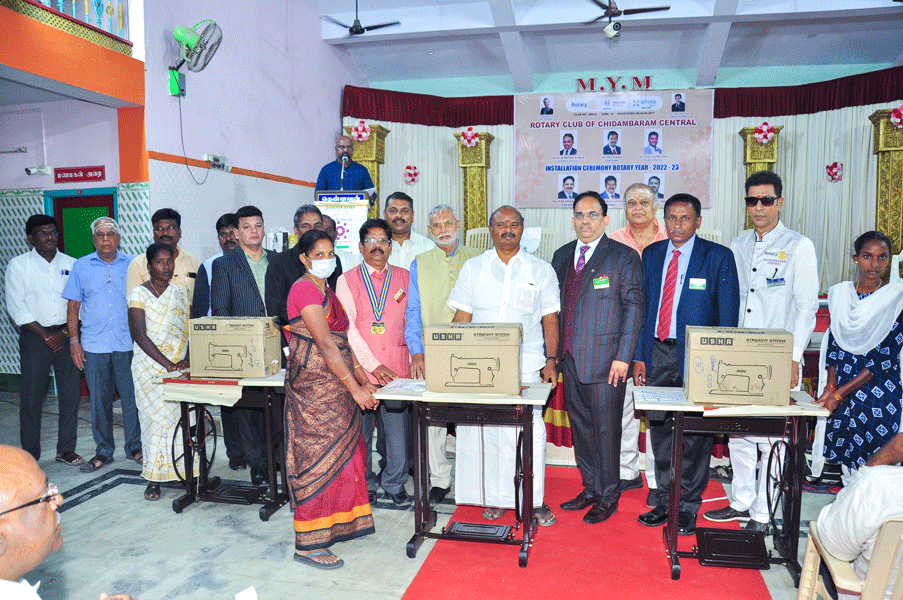 Club members distributing sewing machines to beneficiaries.