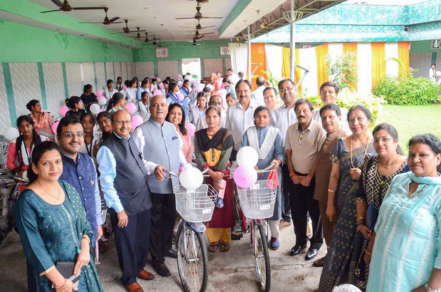 PRIP Shekhar Mehta and Rashi hand over bicycles to students.