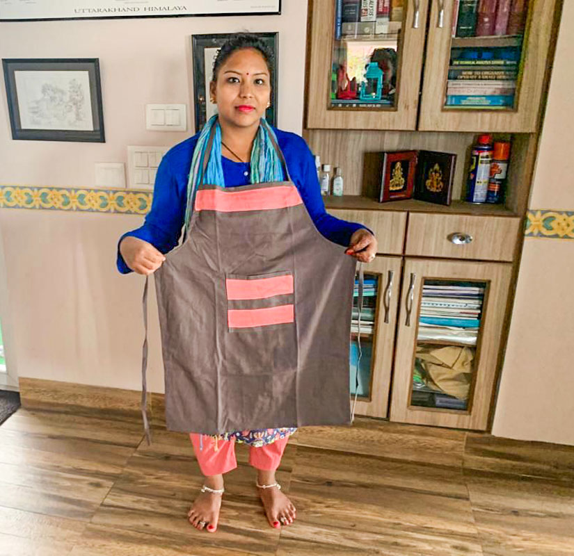 A beneficiary shows off the apron she had stitched.