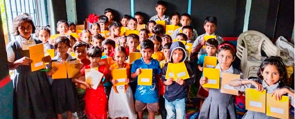 Children display their new notebooks donated by RC Panvel Elite.