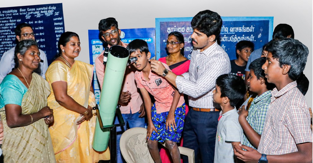 Coimbatore corporation commissioner M Pratap helps a student explore the sky through the telescope built by the students of the Thudiyalur Panchayat Union Middle School.