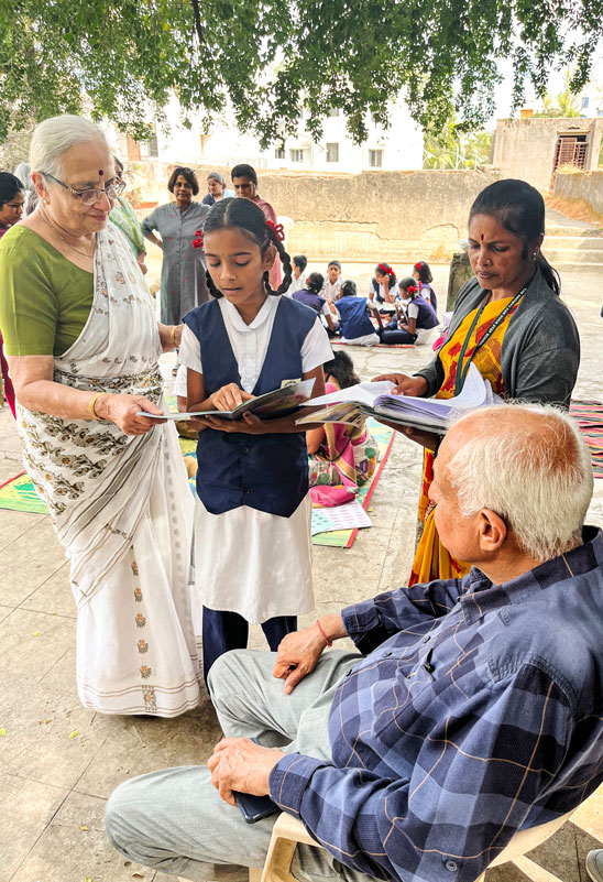 Rajani Paranjpe (L), founder of Doorstep School, interacting with a child as philanthropist Nitin Karia observes the class in progress. 