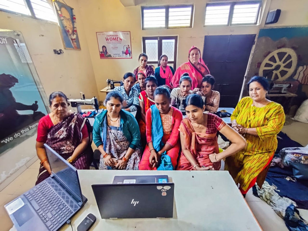 Dr Bindu Shirsath (R) with the women as they watch a demo of stitching a cloth sanitary pad.
