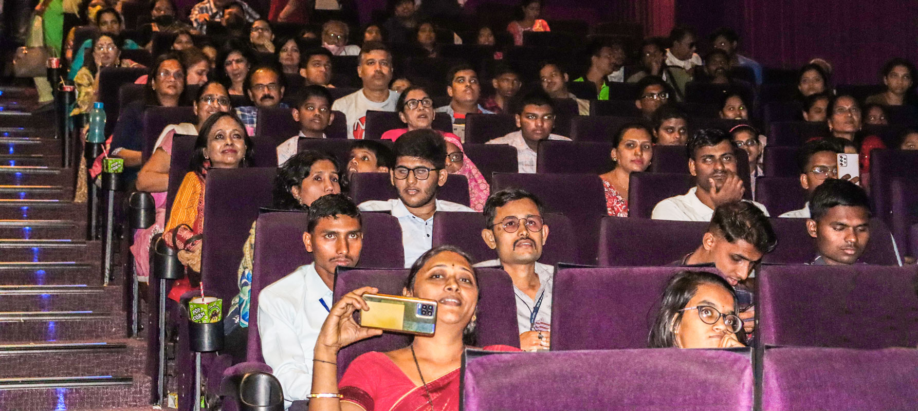 Visually-challenged people with their ‘whisperers’ inside the theatre.