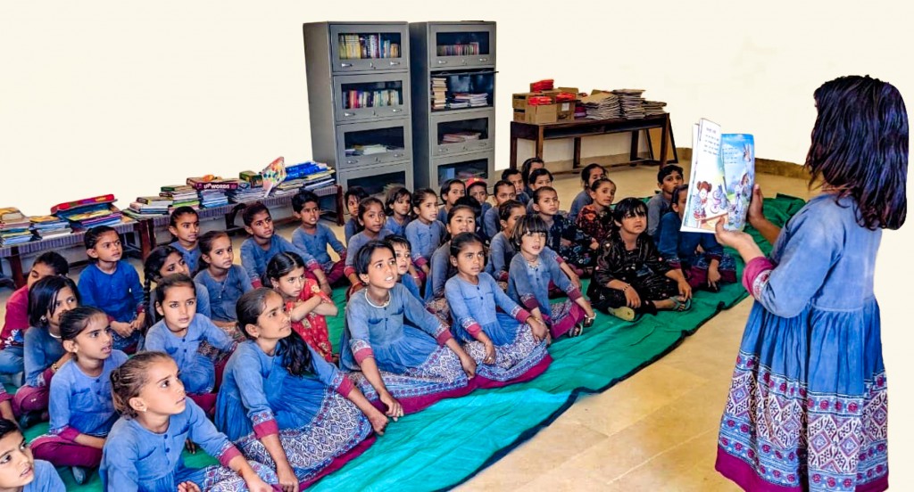Students listen to a child reading a book at the newly installed library in the Rajkumari Ratnavati Girls’ School, Jaisalmer.