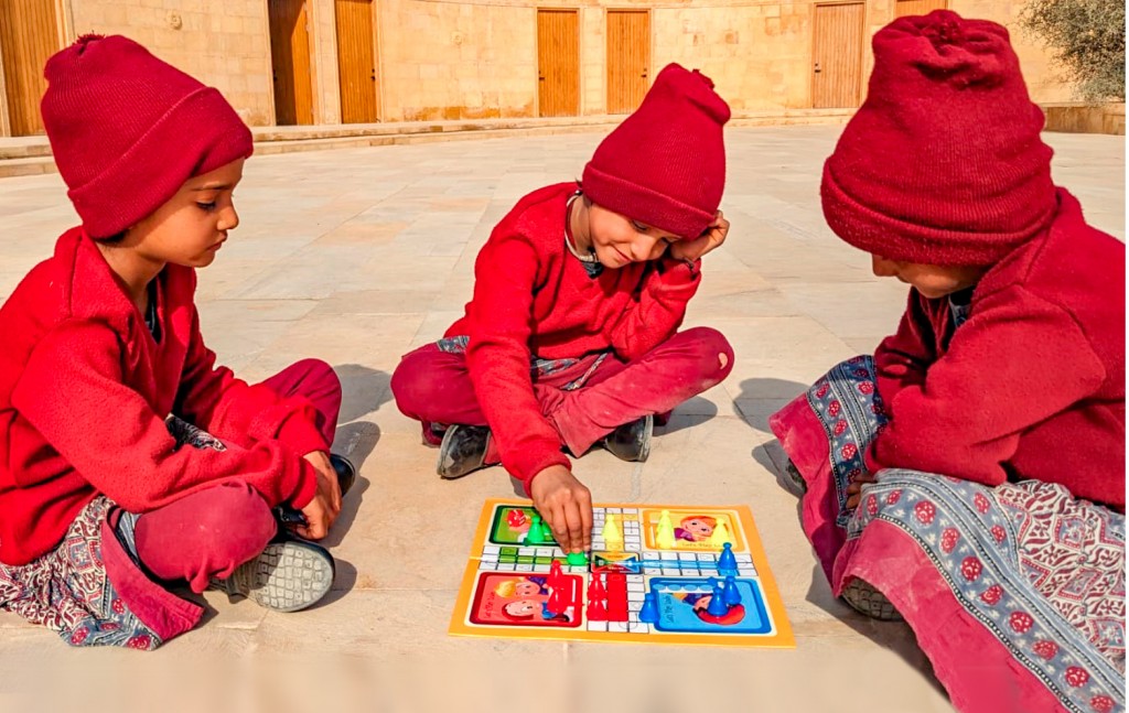 Girls playing Ludo in the school.