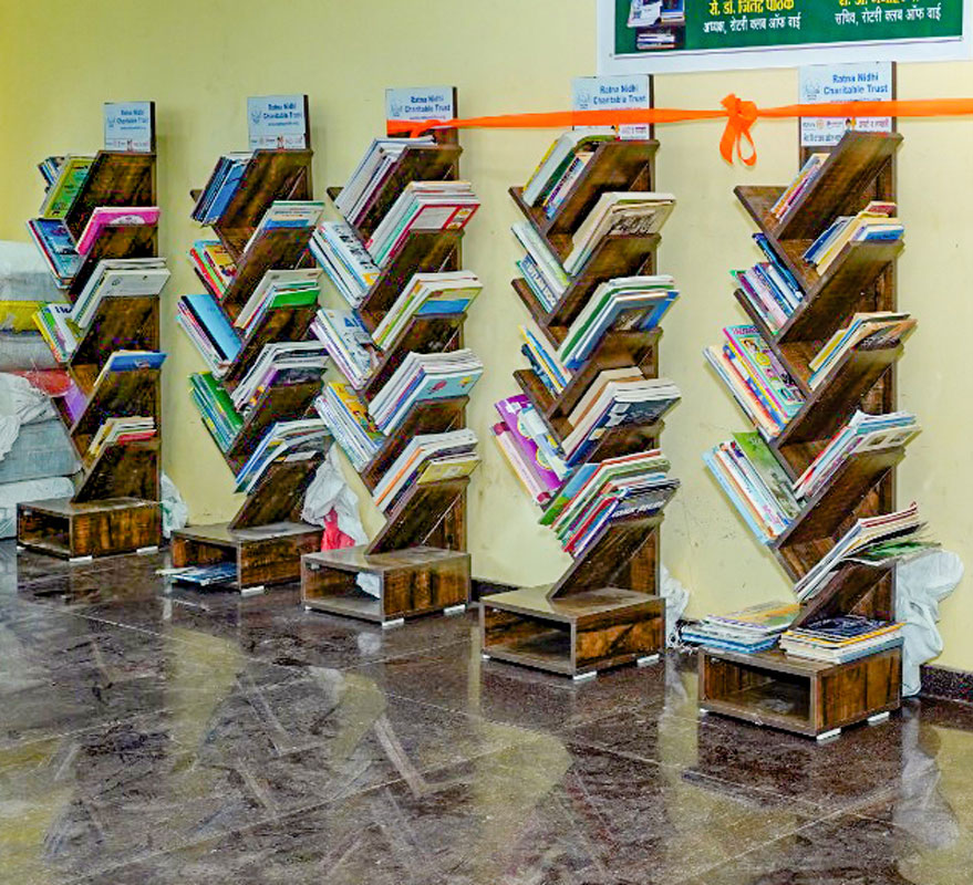 Books gifted by Rotarians neatly stacked in a school library.
