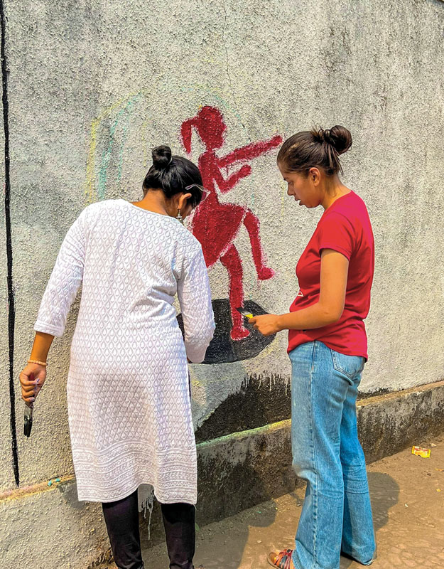 Rotaractors paint walls with images depicting the injustice faced by women.  
