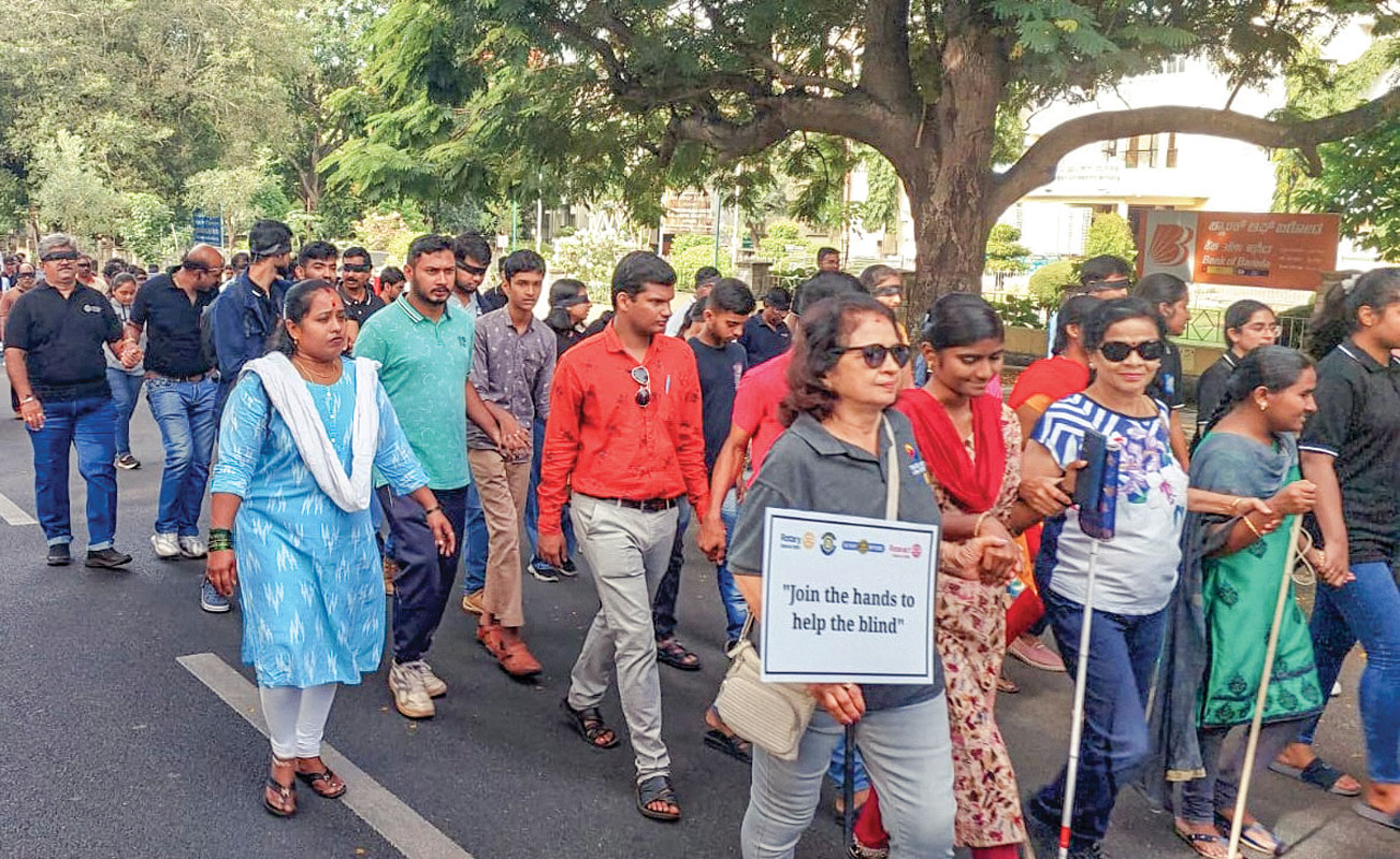 Visually-challenged people leading the march with the help of their white canes. 