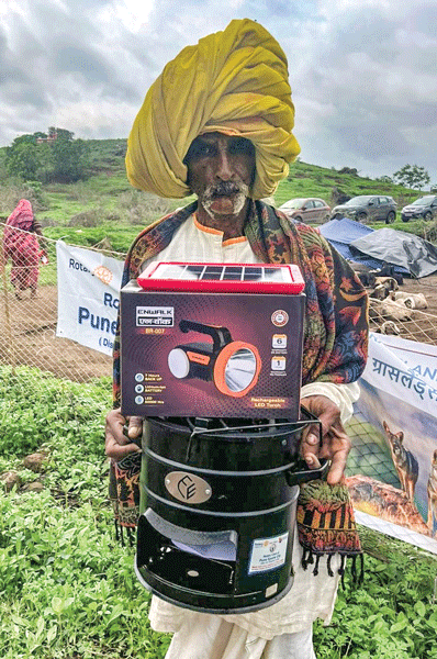 A Dhangar tribal with a solar lighting system and a smokeless chulha given to him by RC Pune Sports City.