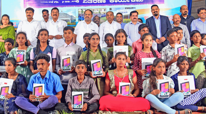 RC Panchsheel Mysore president Kiran Robert (fourth from R) and club members with students after distributing e-tabs to them.